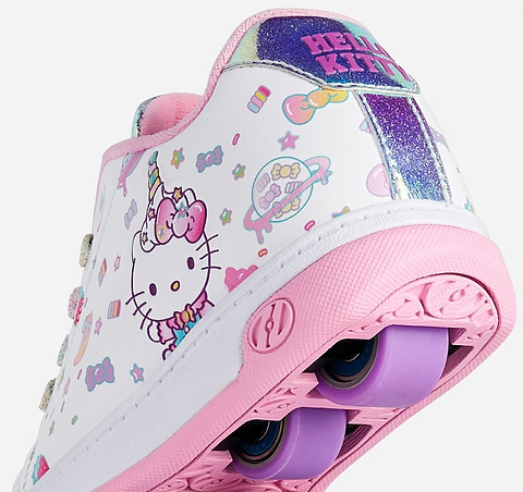 A close-up of the Heelys x Hello Kitty Split X2 Girls Heelys in White/Pink, featuring colorful Hello Kitty and unicorn graphics, pink accents, purple wheels, and glittery heel details—a fun roller skate from Heelys for kids.