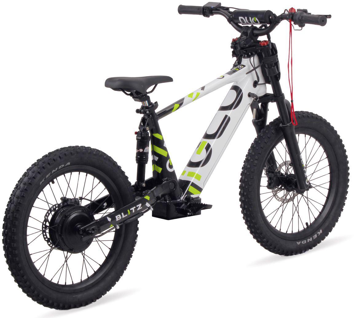The Duo 20" Blitz Kids Electric Balance Bike by Duo, in white and black with green accents, features thick tires, front suspension, and disc brakes. It is shown photographed on a white background.