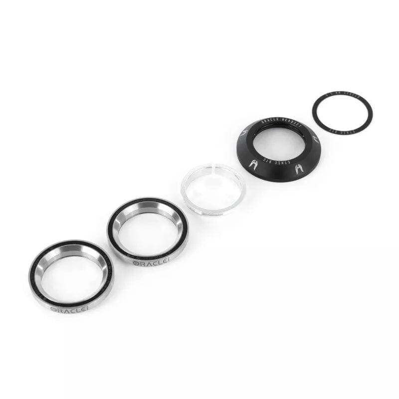 Product Description: The Ethic DTC Oracle Integrated Stunt Scooter Headset - Black by Ethic showcases a set of meticulously arranged components on a white background. This includes two angular contact bearings, a transparent compression ring, a sleek black top cover, and a small rubber seal. Designed for optimal shock management and heavy landings.