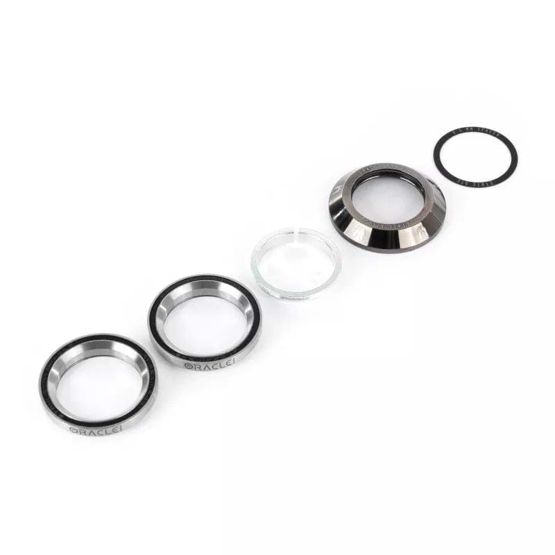 Ethic's Chrome Black Oracle Integrated Stunt Scooter Headset displays a collection of metal and plastic automotive components, including an enhanced compression ring and a small glass element, all elegantly displayed in a row against a white background.