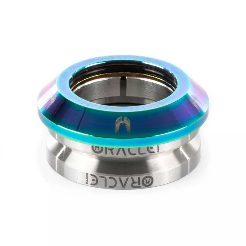 The Ethic DTC Oracle Integrated Stunt Scooter Headset in Neochrome features a metallic, smooth, slightly conical design. The upper section displays a gradient of blue and purple hues, while the lower part is silver with the "RACEFACE" engraving. This headset is built to withstand heavy landings, making it ideal for stunt scooter enthusiasts seeking durability.