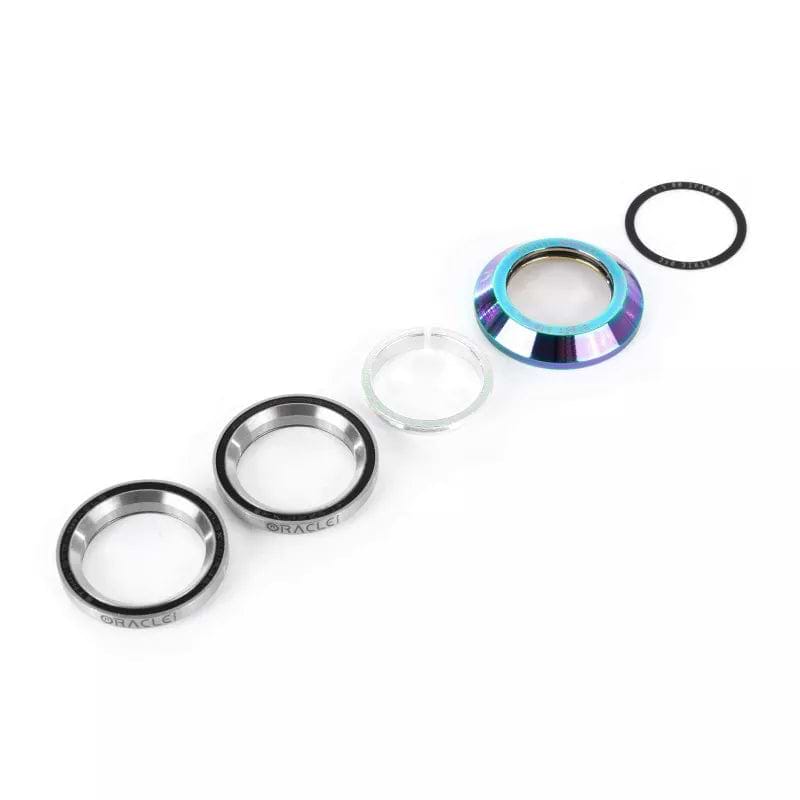 A disassembled Ethic DTC Oracle Integrated Stunt Scooter Headset in Neochrome is arranged horizontally, showcasing its distinct components. Metallic bearings, a translucent spacer, and a multicolored cap are paired with a black sealing ring. Expertly designed to handle shock and heavy landings, each piece is positioned against a pristine white background.