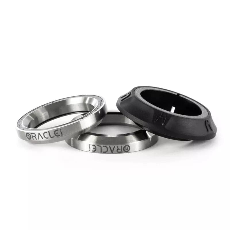 Three Oracle-branded espresso dosing rings are displayed. Two feature a metallic finish crafted from stainless steel, while the third is black and constructed from plastic. Their playful arrangement mirrors the precision of an Ethic Osmose Silicone Integrated Stunt Scooter Headset, seamlessly blending form and function.