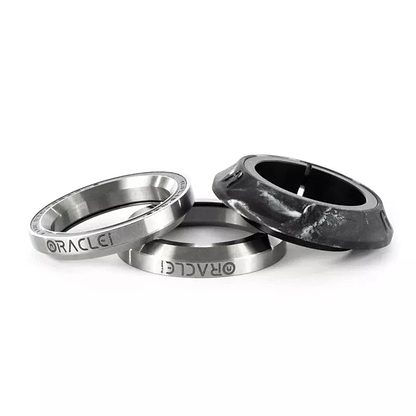 The Ethic DTC Osmose Silicone Integrated Stunt Scooter Headset - Grey features three meticulously designed metal rings stacked together. Two of these rings are smooth and silver with "ORACLE" engraved on them, while the third is a matte black with a textured finish. They are beautifully presented against a white background.