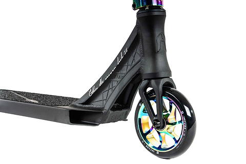 A close-up image showcases the front wheel and deck of an Ethic DTC Erawan V2 Complete Stunt Scooter in neochrome. The wheel has a metallic, multi-colored finish, while the deck features a textured grip surface and subtle silver branding. Enhanced with sleek design elements, this scooter by Ethic includes IHC compression for top-notch performance.