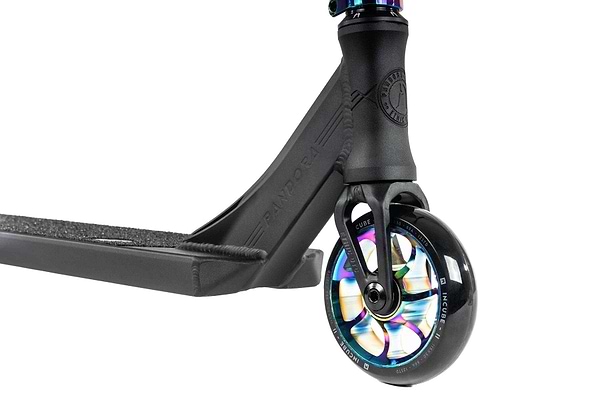 Close-up of the Ethic DTC Pandora Complete Stunt Scooter's neochrome rear wheel with a metallic, multi-colored core. The deck features a textured grip surface, and the frame appears robust, designed for durability and smooth rides. This street-oriented scooter is ideal for riders seeking style and performance.