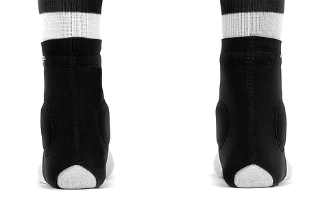 Back view of feet wearing REKD Energy Slim Footies Ankle Protection Pad in black, featuring padded/reinforced heel for added impact protection, shown on a white background.