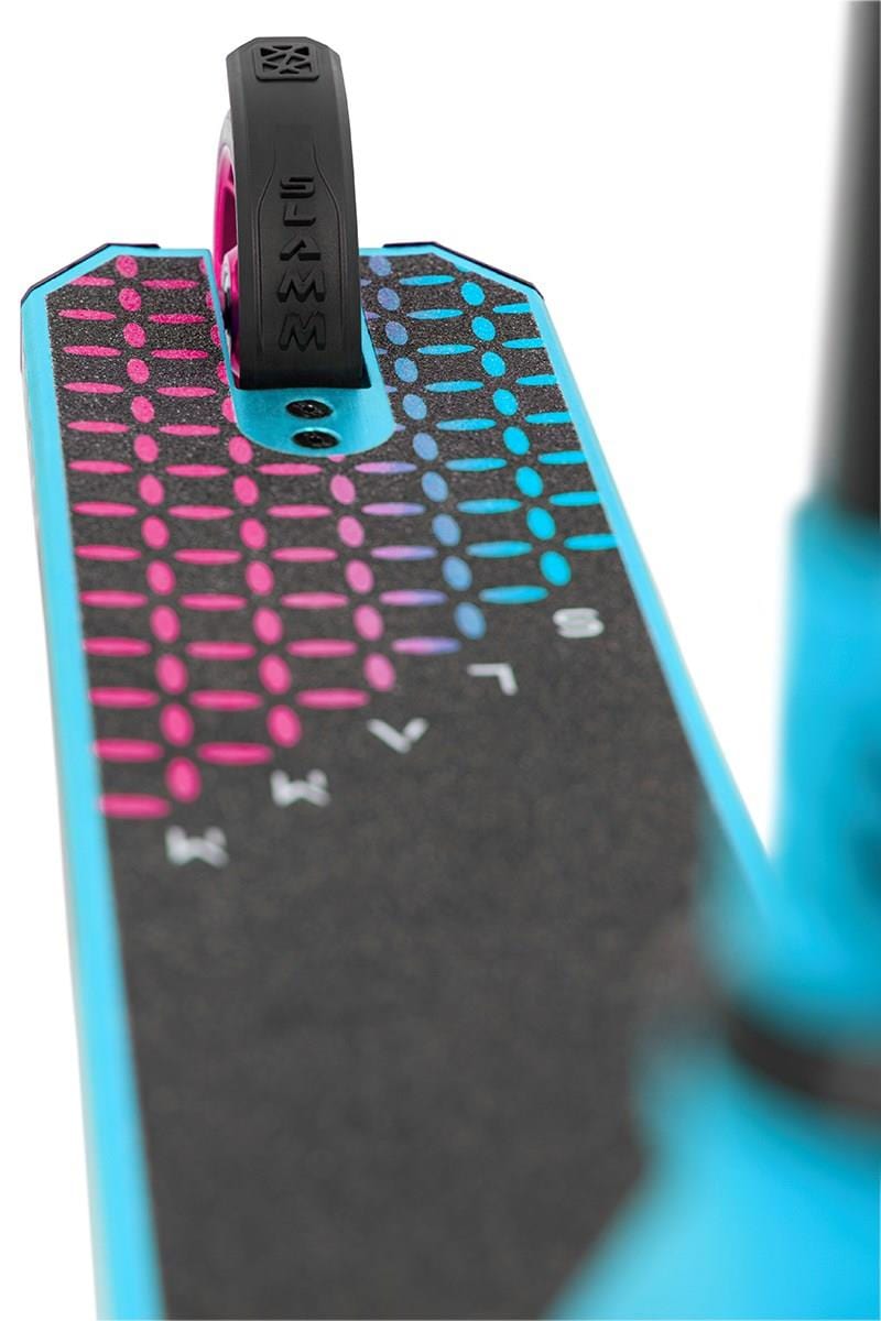 A close-up of a scooter deck shows black grip tape with a vibrant geometric pattern of pink and blue dots. The front wheel, part of the blue frame, and the Slamm Nylon Stunt Scooter Flex Fender - Black are visible, ideal for your stunt scooter brake needs.