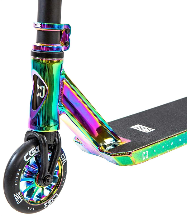Close-up of the CORE CG1 Complete Stunt Scooter in Neochrome/Black, displaying the front wheel with CORE branding, metal fork, and a griptape deck featuring the logo and vibrant rainbow neochrome finish.