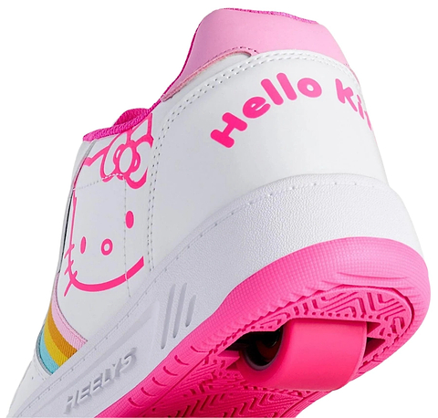 Close-up of Heelys x Hello Kitty Kama Girls Shoes by Heelys in white/pink, featuring Hello Kitty’s face, rainbow stripes on the side, “Hello Kitty” in pink on the heel, and a bright pink sole with matching accents and wheel.