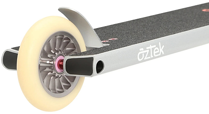 Close-up of the rear section of a platinum silver Aztek Architect 2 Complete Stunt Scooter deck with black grip tape, showing a white wheel with a gray core and metal brake. The Aztek brand name is visible on the side of this street scooter.