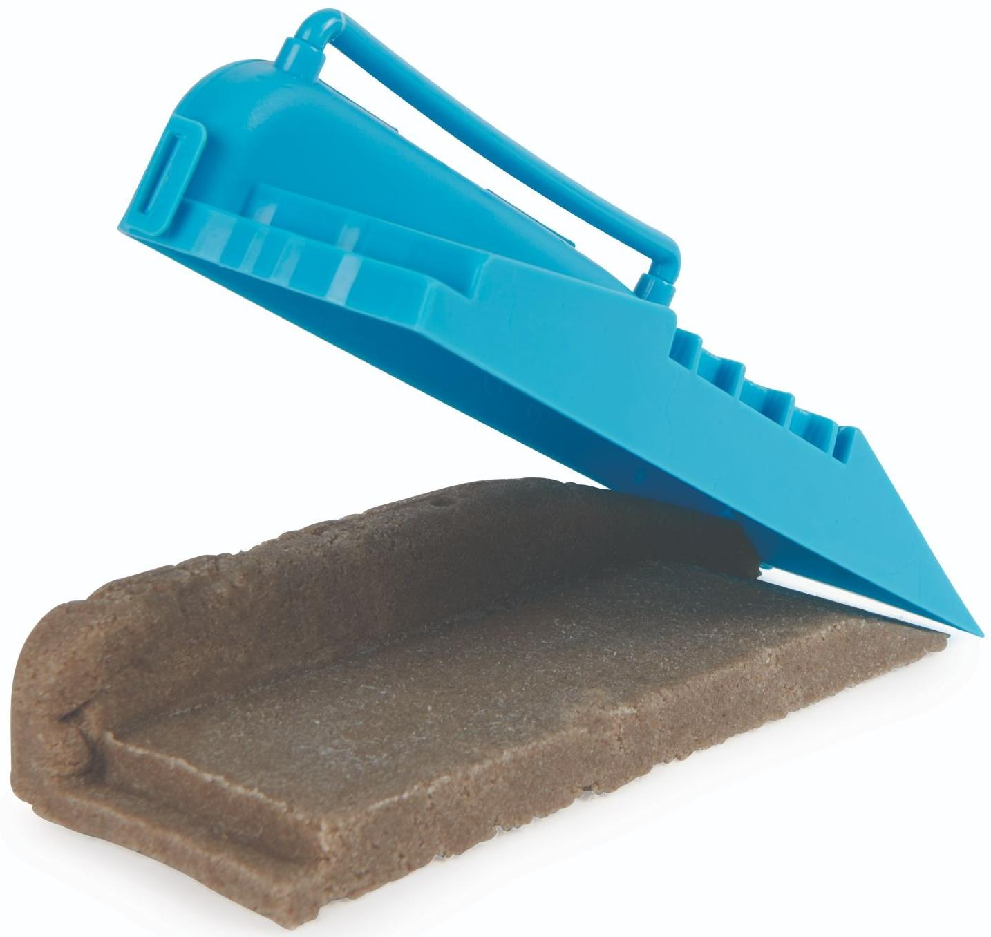 A blue plastic mold with a handle lifts from compact brown sand, leaving an imprint—perfect for use in your Tech Deck DIY Concrete Reusable Fingerboard Ramp Modelling Set by Tech Deck.
