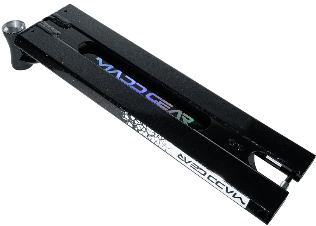 The Madd Gear MGP VX Origin Black Stunt Scooter Deck (5.5″ x 20.5″) lies flat against a white background, displaying the Madd Gear logo on both the top and side panels, along with a distinctive cracked design at one end. This deck features a cutout center, making it an ideal choice for park riders.
