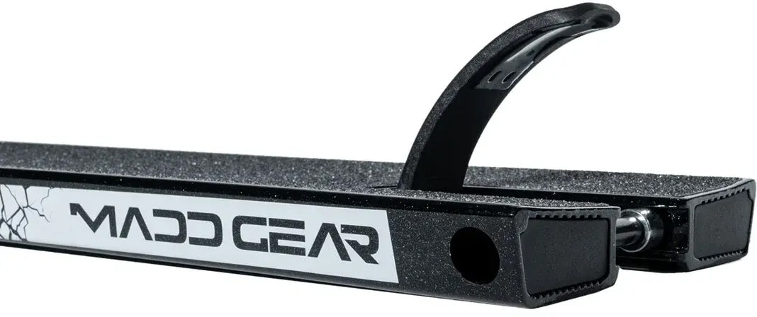 Close-up of the Madd Gear MGP VX Origin Black Stunt Scooter Deck (5.5″ x 20.5″) featuring a white MGP logo, griptape surface, and a curved metal brake at the rear—designed for park riders seeking a reliable pro deck.