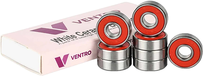 Eight metal ball bearings with red centers are stacked beside a pink and white Ventro box labeled "White Ceramic," indicating a set of high-performance Ventro Ceramic ABEC 11 Red Bearings (set of 8), designed for skateboard use in the standard 608 size.