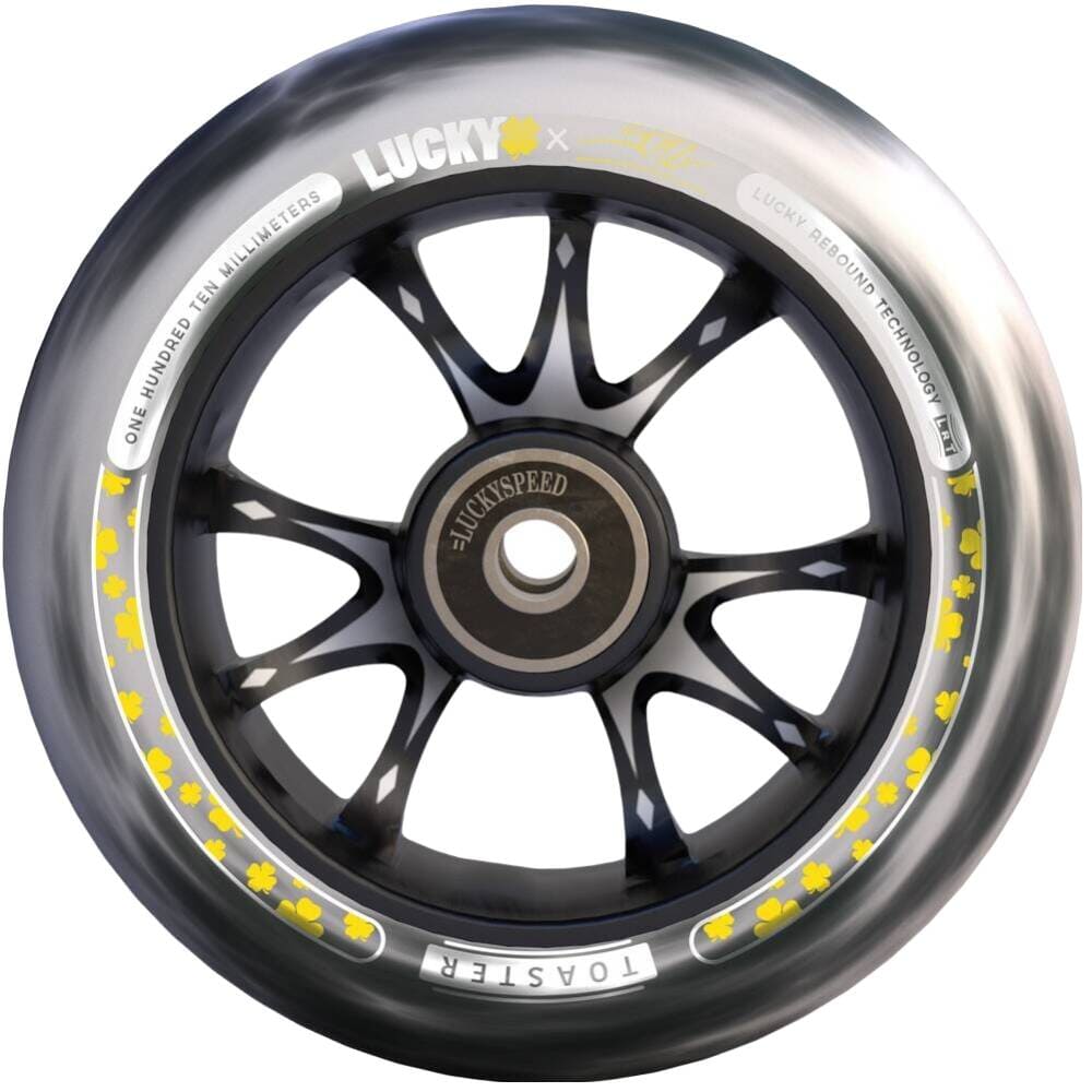 A detailed image of the wheel from the Lucky Toaster 110mm Stunt Scooter Wheel - Jon Marco Gaydos JMG Signature V4 highlights its sleek black design adorned with yellow floral patterns along the edge. The wheel features the brand name "Lucky" and includes text stating "one hundred ten millimeters" alongside "Lucky bearing technology," making it an ideal choice for fans of scooter accessories.
