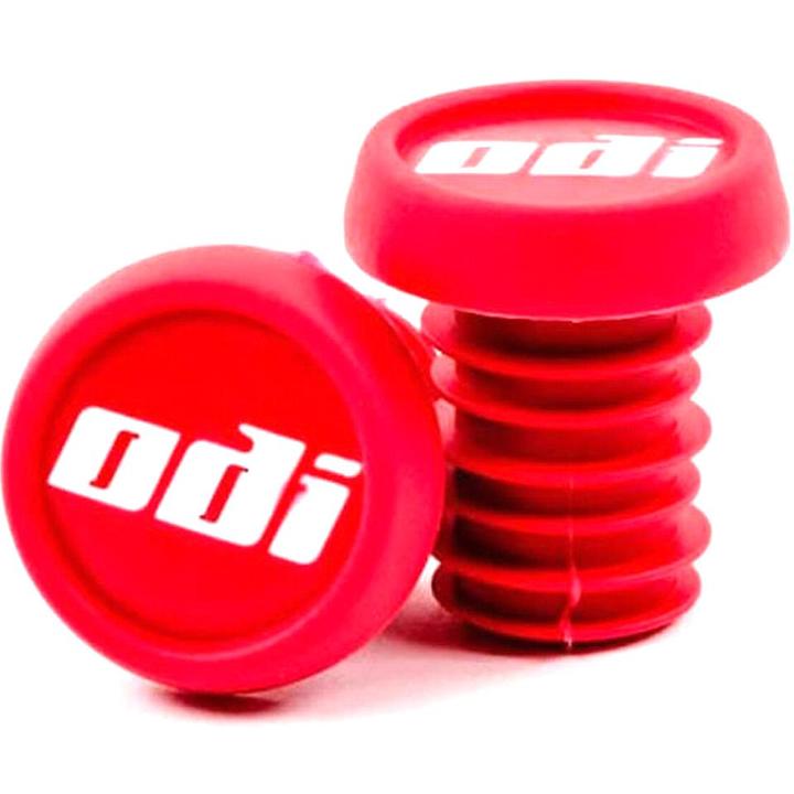 Two red ODI Push-In Stunt Scooter Bar Ends with the "odi" logo in white text, made from durable resin. One bar end is upright while the other leans against it, displaying its threaded side.