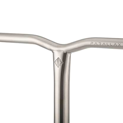 A close-up of the metallic handlebar showcases the minimalist design of the Drone Parallax Titanium HIC Stunt Scooter Y-Bars. "PARALLAX" is engraved on one side, while a geometric logo embellishes the intersection of the durable titanium bars, all presented in a sleek, brushed finish.