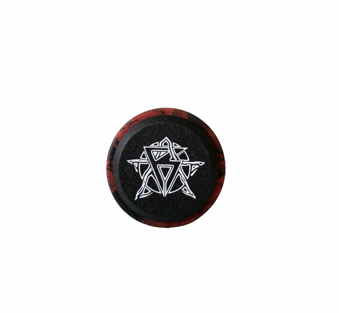 A circular item, potentially resembling a hockey puck, showcases a white geometric star pattern on its surface. It is accented with a red and black marbled border and features a matte-black center, reminiscent of the high-quality material used in the Revolution Fused Black / Red Stunt Scooter Grips by Revolution.