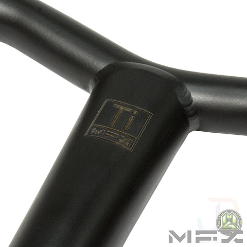 Close-up of a black metal handlebar from the Madd Gear MGP MFX BAMF Titanium Oversized SCS Stunt Scooter Bar, featuring the "MGP" logo on the stem. The bar is crafted from Grade 9 Titanium and the image is set against a white background with an additional logo in the bottom right corner.