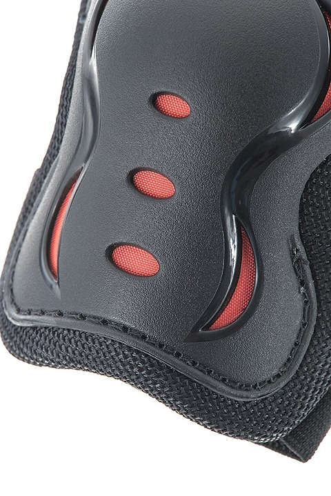 Close-up of a black and red protective gear, possibly a knee or elbow pad from the SFR Essentials Junior Triple Skate Protection Pad Set - Black, featuring three ventilation holes and a textured surface, offering entry-level protection with integrated impact caps.