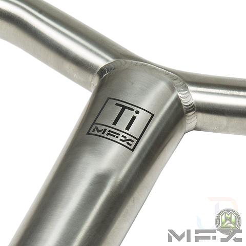 Close-up of a metal T-joint with a smooth weld, featuring the logo "Ti MFX" printed on the surface. Crafted from Grade 9 Titanium, this piece showcases exceptional craftsmanship and robust design, similar to the Madd Gear MGP MFX BAMF Titanium Oversized SCS Stunt Scooter Bar - Raw 660mm x 660mm. The plain background accentuates its shiny, metallic texture.
