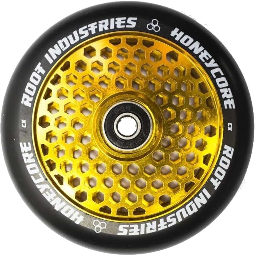 A close-up of the Root Industries Honeycore 120mm stunt scooter wheel in a captivating black and gold honeycomb pattern, elegantly inscribed with "Root Industries" on its outer edge. This sleek and modern design is further enhanced by the premium Root bearings, making these Honeycore wheels an exceptional choice for any rider.