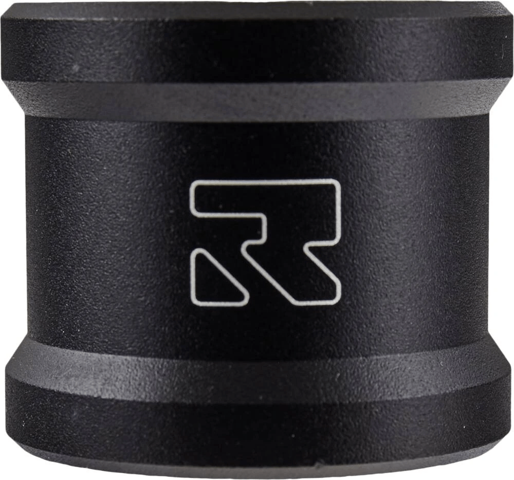 The Root Industries Lithium 2 Bolt Oversized Stunt Scooter Clamp in black is a cylindrical device crafted with aircraft-grade aluminum and a matte finish, prominently displaying the white stylized "R" logo at its center. It features slightly beveled edges on the top and bottom, adding to its sleek durability.