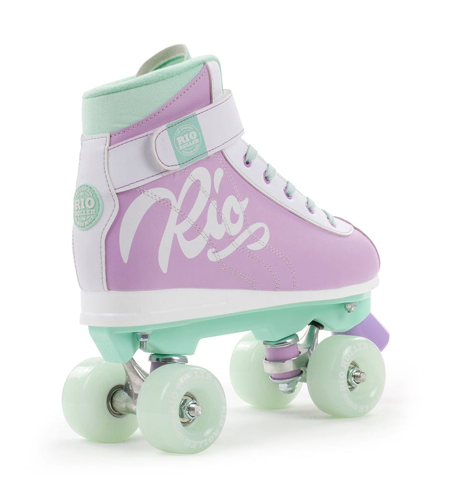 Introducing the Rio Roller Milkshake Quad Roller Skates - Mint Berry from Rio Roller—a delightful blend of pastel-colored perfection. This high-top roller skate features a lavender boot with mint green accents on the wheels, sole, and lining. A chic white script "Rio" graces the side, complemented by a convenient Velcro strap at the top.