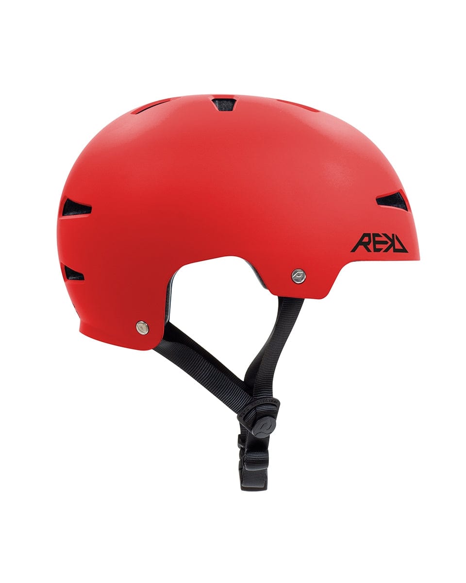 Side view of the REKD Elite 2.0 Skate / Scooter Helmet in red, showcasing its black ventilation holes and adjustable chin strap. The helmet prominently features a logo on the side with bold black letters.