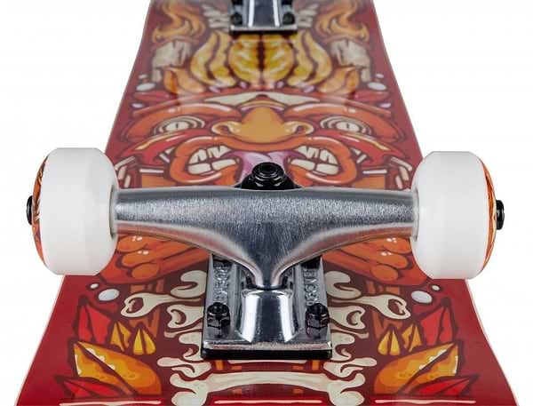 Close-up of the Rocket Chief Pile-Up Red Complete Skateboard (7.75" x 31") for beginners, featuring white wheels, aluminum trucks, a 7-ply hardrock maple deck, and an intricate orange and yellow face graphic.