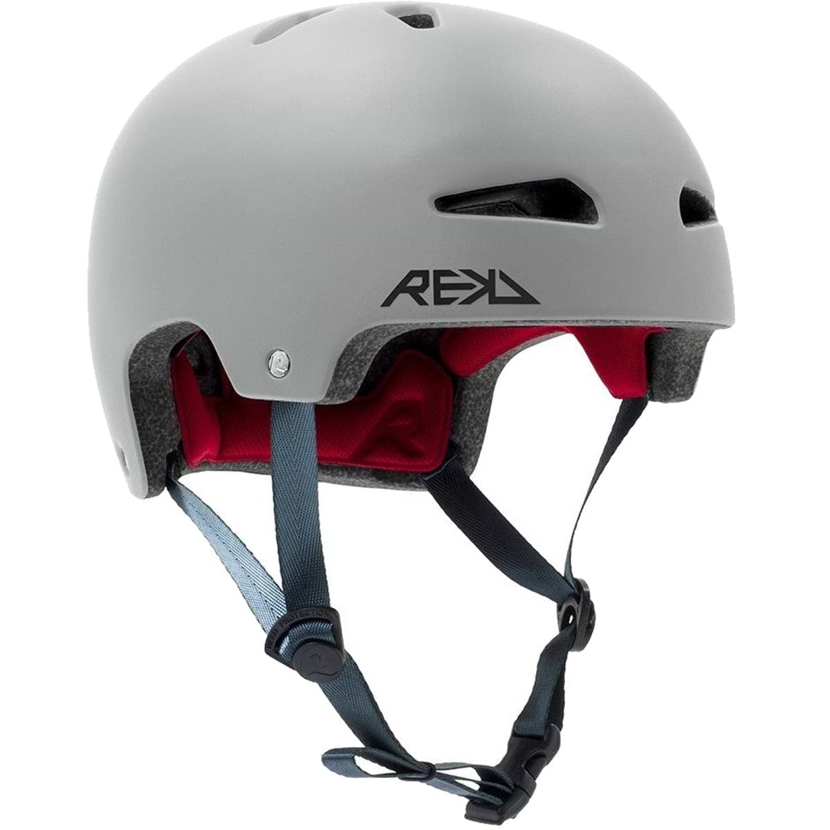 The REKD Ultralite In-Mold Skate / Scooter Helmet in grey is ideal for action sports, equipped with advanced In-Mold technology. This protective helmet features a red interior padding and proudly displays the "REKD" logo on the side. It offers comfort with multiple ventilation holes, adjustable black chin straps, and a blue buckle for secure fastening.