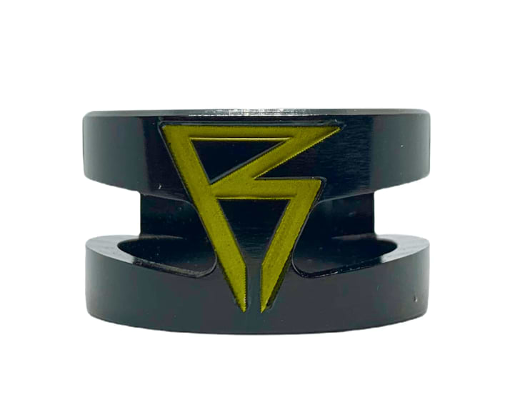 Introducing the Revolution Super Lite 2 Bolt Oversized Stunt Scooter Clamp in black. This sleek accessory showcases a striking angular "B" logo in green at its center, crafted with precision from high-quality 6061-T6 aluminum and featuring an eye-catching glossy finish.