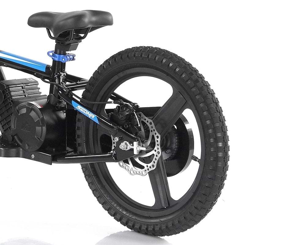 The image features a close-up of the rear wheel and seat of a Revvi 16" Plus Kids Electric Balance Bike in black with blue accents. It showcases its disc brake and wide, rugged tire with a distinct tread pattern, ideal for those who value quality in children's electric bikes. Notably, this model is available in an Orange variant under the Revvi brand name.