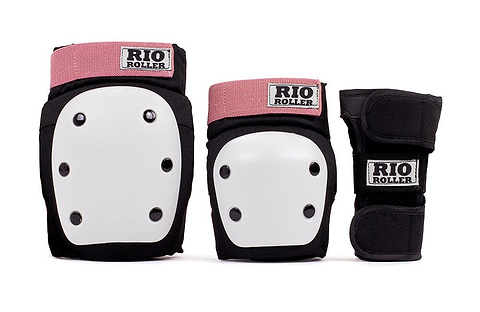 The Rio Roller Triple Skate Protection Pad Set - Black / Rose by Rio Roller includes a ramp-style set with dual splint wrist guards, black knee pads, and elbow pads. The gear features white plastic shields and rose-colored fabric accents for added flair.