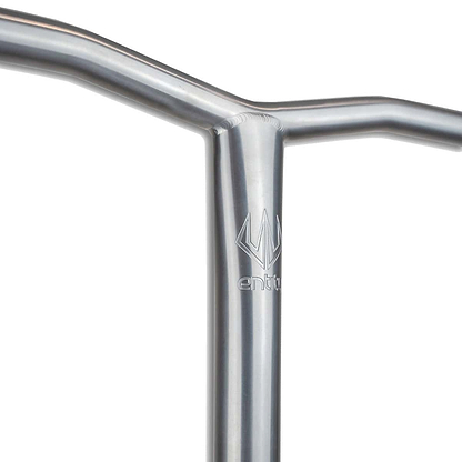 A close-up of the Entity Seraph Titanium Oversized SCS Stunt Scooter Bars in silver showcases a handlebar made from space-grade titanium. Featuring a minimalist design with the "Entity" logo prominently displayed, the surface is smooth and reflective, emphasizing its remarkable strength-to-weight ratio and robust construction.