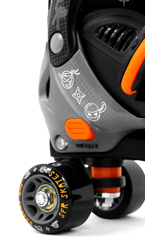 Close-up of the SFR Storm V Adjustable Quad Roller Skates - Ninja, featuring a grey and orange design. The black wheel is adorned with orange "SFR Skate" lettering. Playful graphics on the side of these children's skates include a cartoon face and geometric shapes.