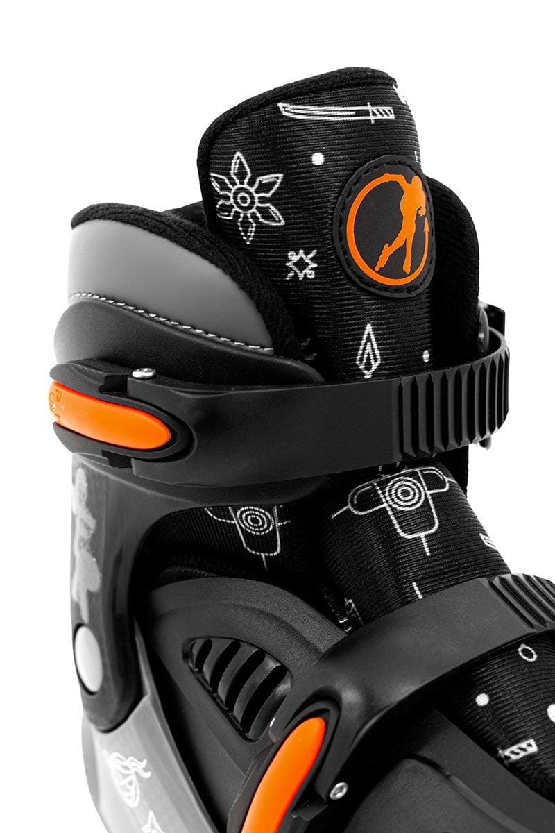 Detailed view of the SFR Storm V Adjustable Quad Roller Skates - Ninja, characterized by a black hard boot design with striking orange accents. The skates are adorned with white geometric patterns such as arrows and targets. The tongue prominently displays the SFR logo featuring an orange silhouette, making these skates perfect for young roller skating enthusiasts who appreciate size-adjustable options.