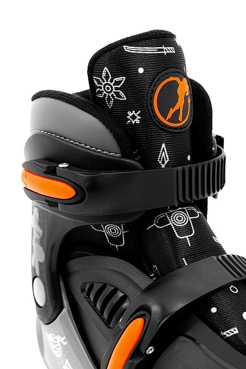 Detailed view of the SFR Storm V Adjustable Quad Roller Skates - Ninja, characterized by a black hard boot design with striking orange accents. The skates are adorned with white geometric patterns such as arrows and targets. The tongue prominently displays the SFR logo featuring an orange silhouette, making these skates perfect for young roller skating enthusiasts who appreciate size-adjustable options.