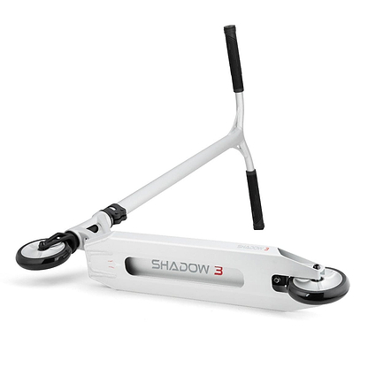 A silver anodized scooter from Drone, featuring a Y-shaped handlebar, is displayed on its side with the "Drone Shadow 3" design boldly visible on the deck in black and red. This Feather-Light Complete Stunt Scooter includes two small black Helios hollow-spoked wheels and comfortable black grips on the handles.