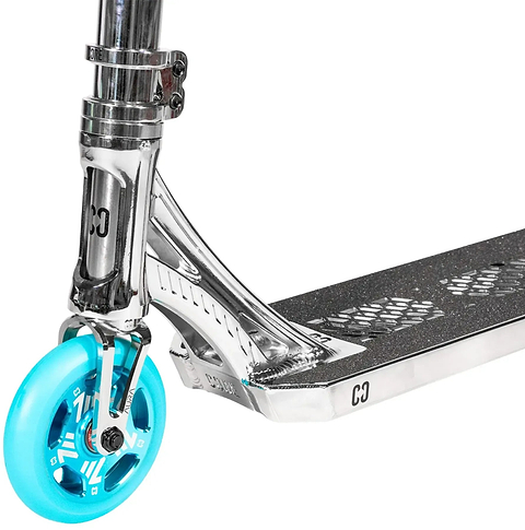 Close-up of the CORE SL3 Mini Complete Stunt Scooter by CORE in Chrome / Teal, highlighting its blue front wheel, metal fork, and black grip tape with cut-out hexagon patterns on the deck.
