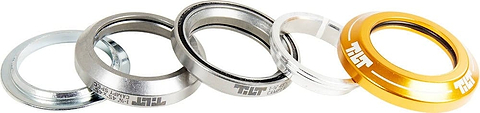 Close-up image featuring the Tilt Integrated Stunt Scooter Headset - Gold, showcasing a gold ring and several silver rings with precision-sealed bearings. The rings are arranged in a slightly overlapping line on a white background.