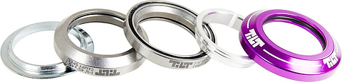 A set of five sleek, metallic, and plastic headset spacers is displayed in a row. These stylish silver and purple spacers include one featuring "Tilt" inscribed in white text. Each piece boasts a smooth, shiny finish, making them the perfect addition to your Tilt Integrated Stunt Scooter Headset - Purple setup.