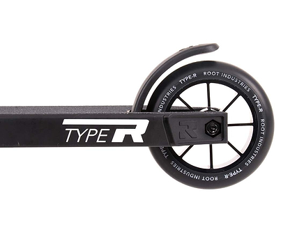 The close-up of a wheel on the Root Industries Type R Complete Stunt Scooter - Black features "ROOT INDUSTRIES TYPE R" printed on the rim, emphasizing its sleek design. This minimalist aesthetic is echoed in the frame, which also prominently displays "TYPE R," with the wheel smoothly integrated into a streamlined deck.