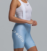 Pedla Women's SuperFIT 2.0 powder blue cycling bib shorts close-up, high-compression Italian fabric, breathable mesh top with white straps, Elastic Interface chamois, seamless non-stitched cuff, aerodynamic fit and reflective logos