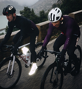 Pedla RideFLASH reflective cycling booties (overshoes) on road cyclists — Vizlite 26% glass high-visibility material visible over 1 km, Velcro base foot binding, signature Pedla detailing for night riding safety