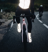 RideFLASH Vizlite™ reflective cycling booties (26% glass) over road bike shoes at dusk, high-visibility reflective overshoes/shoe cover with Pedla velcro base binding and signature Pedla detailing — night cycling safety for commuters and road riders, visible from over a kilometre when hit with light.