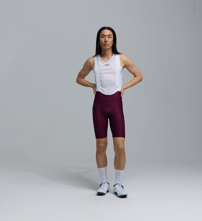 Pedla SuperFIT 2.0 men's cycling bib shorts in fig (maroon) with white mesh straps, Italian performance fabric, Elastic Interface chamois, aerodynamic fit, seamless cuff and reflective logos
