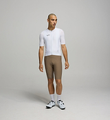 Front view of male cyclist in Core White Classic Jersey – form-fitting silhouette with extended sleeves and low collar designed for aerodynamic road performance.