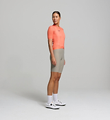 Side angle of apricot women’s summer cycling jersey – close-cut fit with high-stretch materials and mesh ventilation zones on sleeves and side panels for breathability on intense rides.